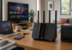 Routeur ASUS RT-BE92U installé sur un bureau dans un intérieur moderne très connecté, avec TV, ordinateur portable, smartphone et stockage réseau