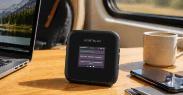 Routeur mobile NETGEAR Nighthawk M3 posé sur une table en bois à côté d’un ordinateur portable, d’un smartphone, d’un carnet et d’une tasse