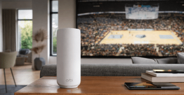 Routeur Wi-Fi mesh NETGEAR Orbi RBE373 posé sur un meuble dans un salon moderne