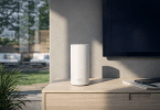 Système WiFi mesh NETGEAR Orbi RBE773 posé sur un meuble dans un salon lumineux