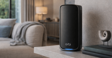 Une borne NETGEAR Orbi RBE973SB posée sur un meuble dans un salon lumineux.