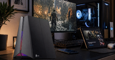 Routeur TP-Link Archer GE550 v1 installé sur un bureau gaming domestique avec écran, PC et usages connectés en arrière-plan