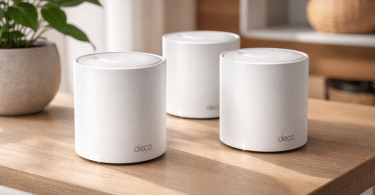 Trois bornes Wi-Fi mesh TP-Link Deco X1500 blanches posées sur une table en bois dans un intérieur moderne