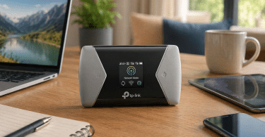 Routeur mobile TP-Link M7450 posé sur une table en bois à côté d’un ordinateur portable, d’une tablette, d’un smartphone et d’un carnet